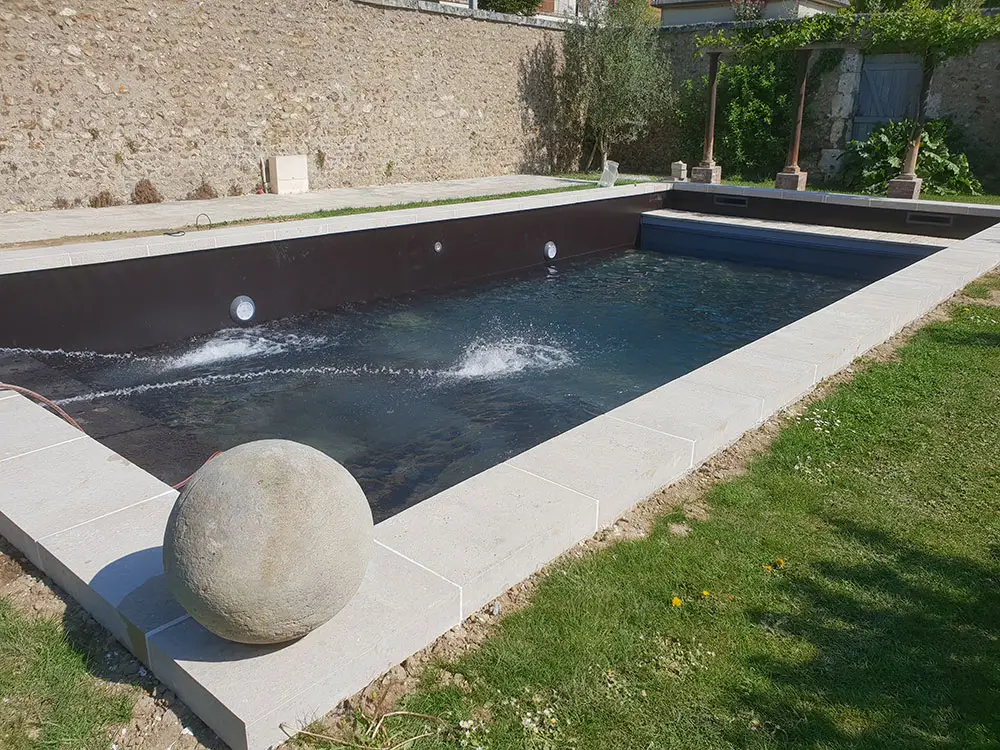 Piscine extérieure contemporaine avec revêtement foncé et margelles en pierre – Design Pool Maroc Marrakech